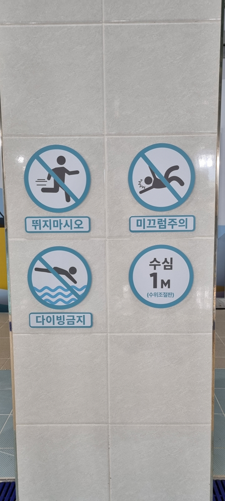 현장 타일 벽면에 적용된 주의 안내 사이니지 실사 사진
